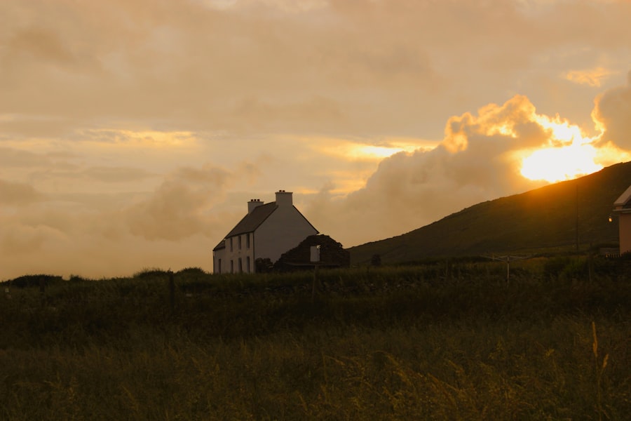 A house on a hill with a sunset in the background