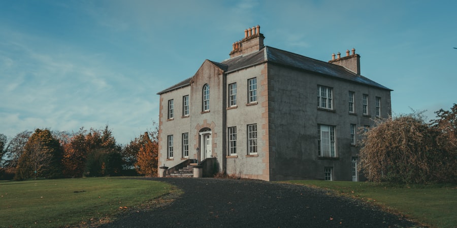 A large grey house sitting on the side of a road